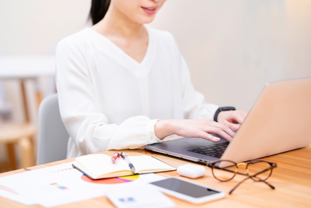 自宅でノートパソコンを使って作業する女性